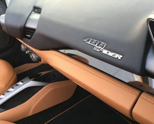 488 tableau de bord Car4rent Luxury sports car interior with tan leather dashboard and 488 Spider badge.